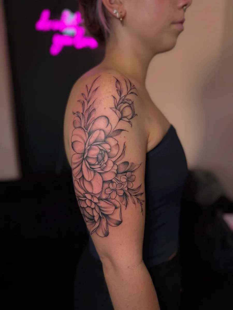 Florale Fine-Line-Arbeit an Schulter und Oberarm